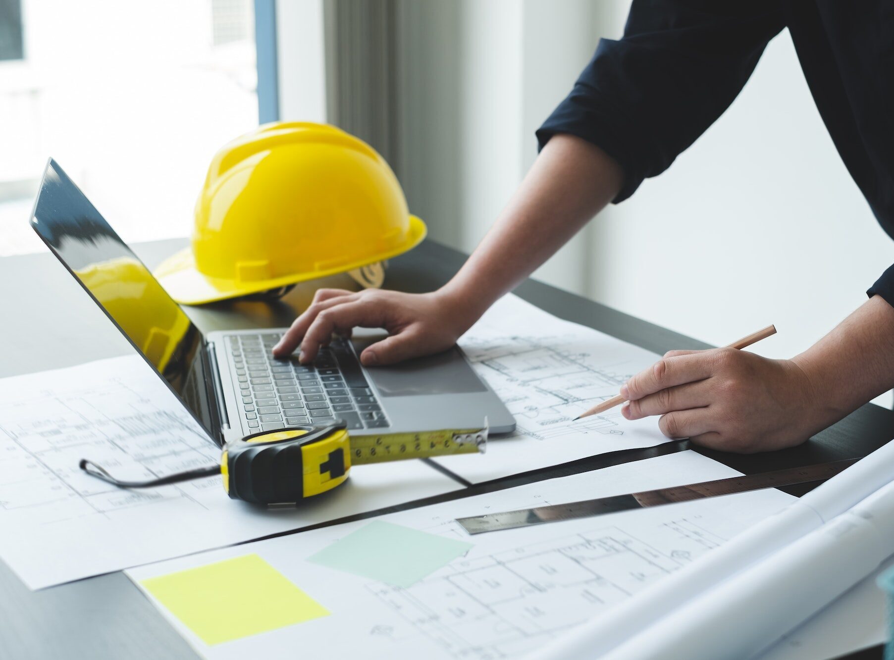 Architects or engineers working construction and drawing construction plans, printing, writing