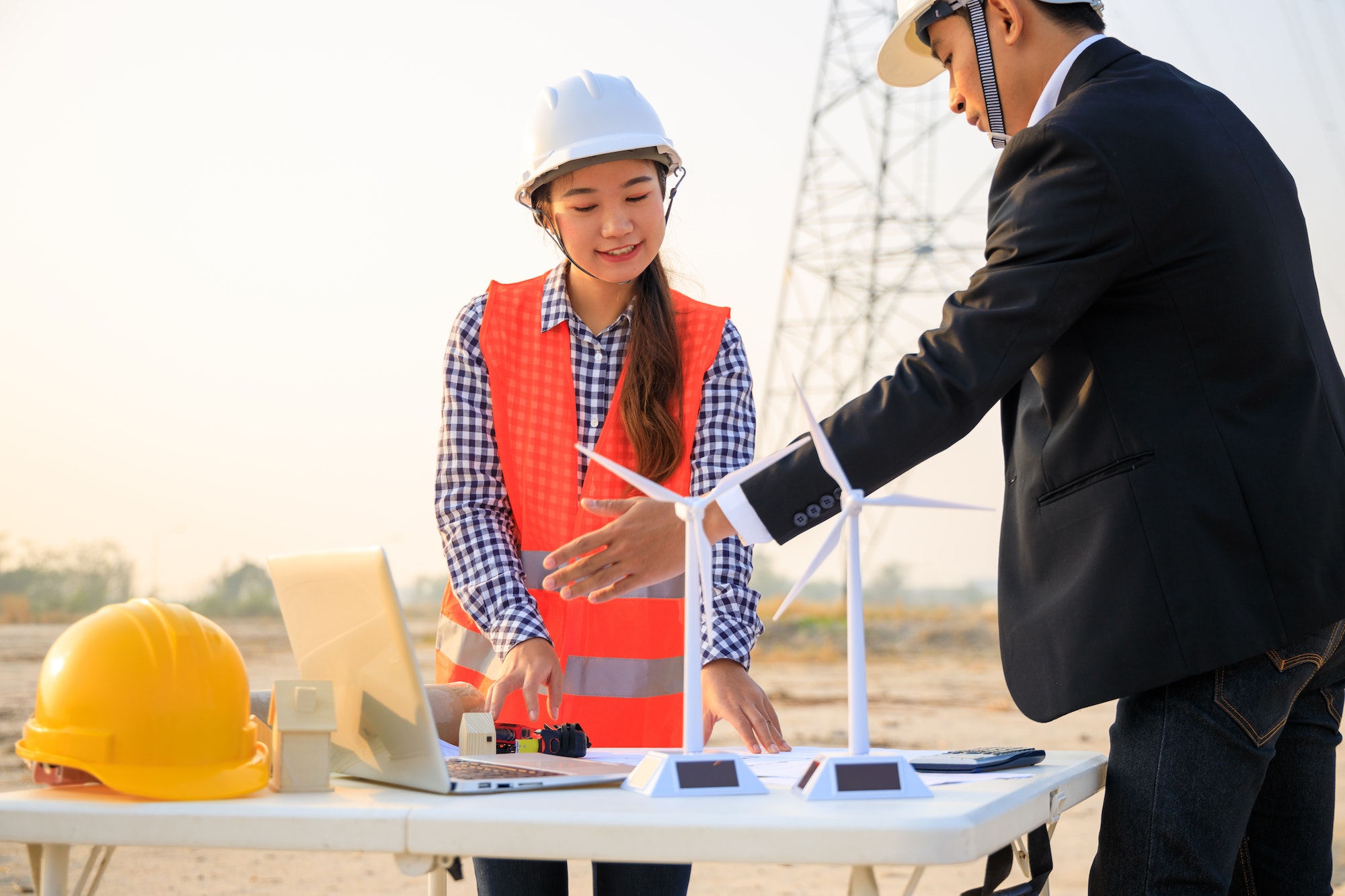 Construction engineers reviewing blueprints on site